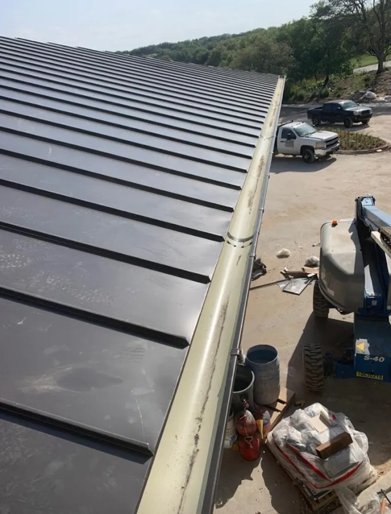 Standing seam panel and gutter detail on a metal roofing jobsite in Sherman
